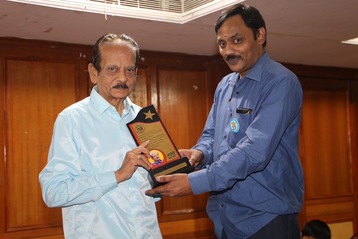 M. Soundrapandian (left) receives a plaque at a reader event.