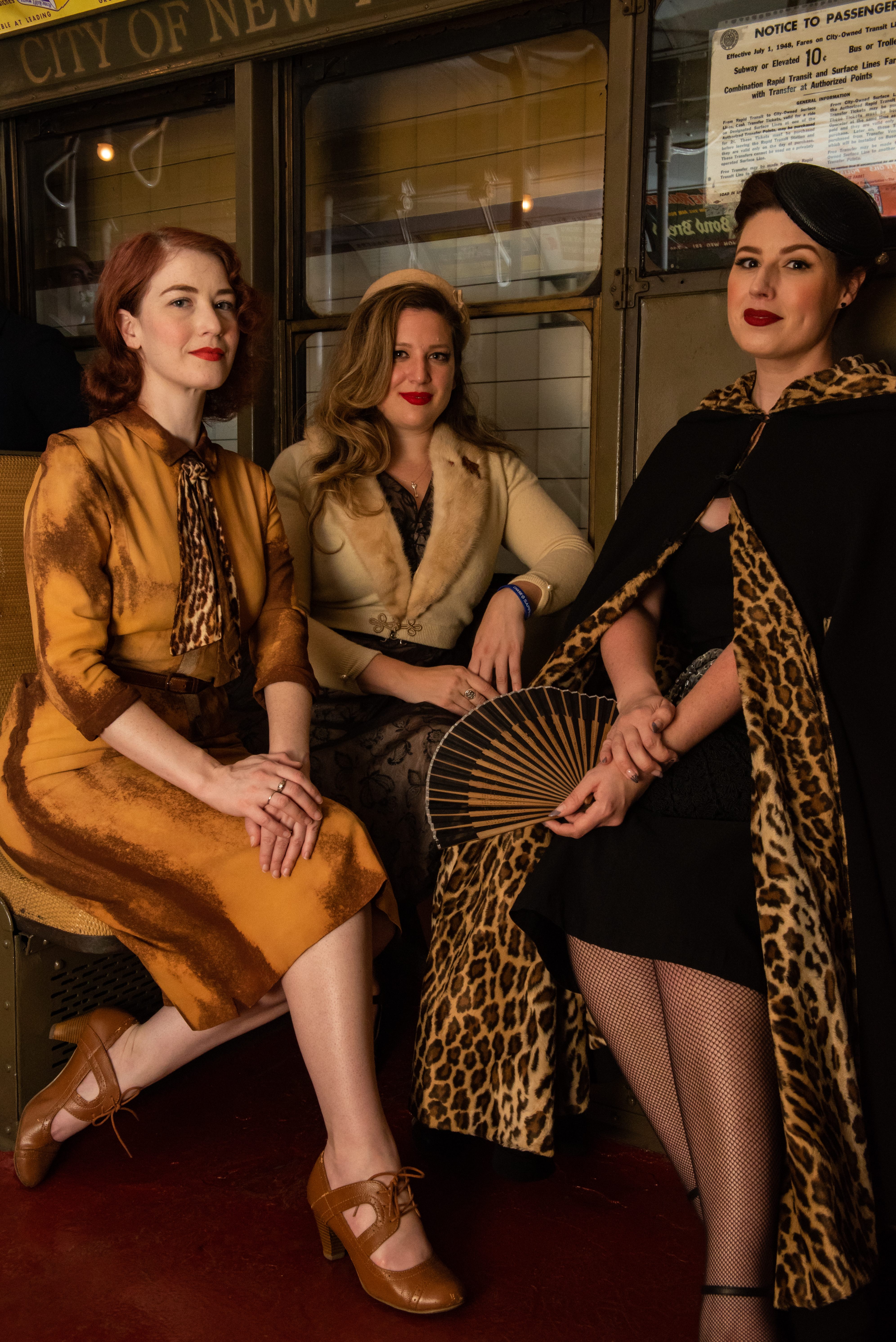 Women dressed in vintage attire take a seat in the train's oldest car.