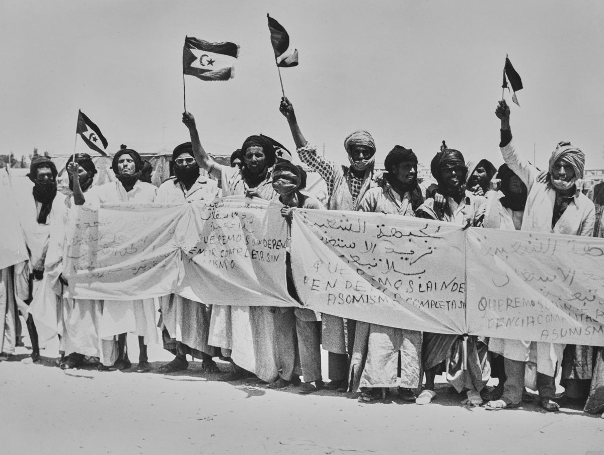 People wave flags of the Polisario Front on a road in Western Sahara on May 20, 1975, where the UN Committee met to assist in the decolonisation process.