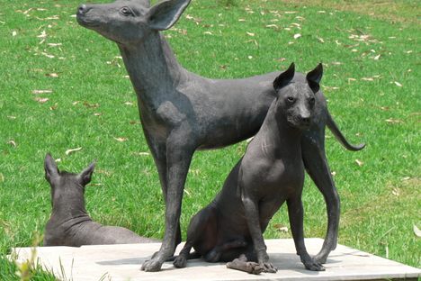 Real dogs next to a statue.