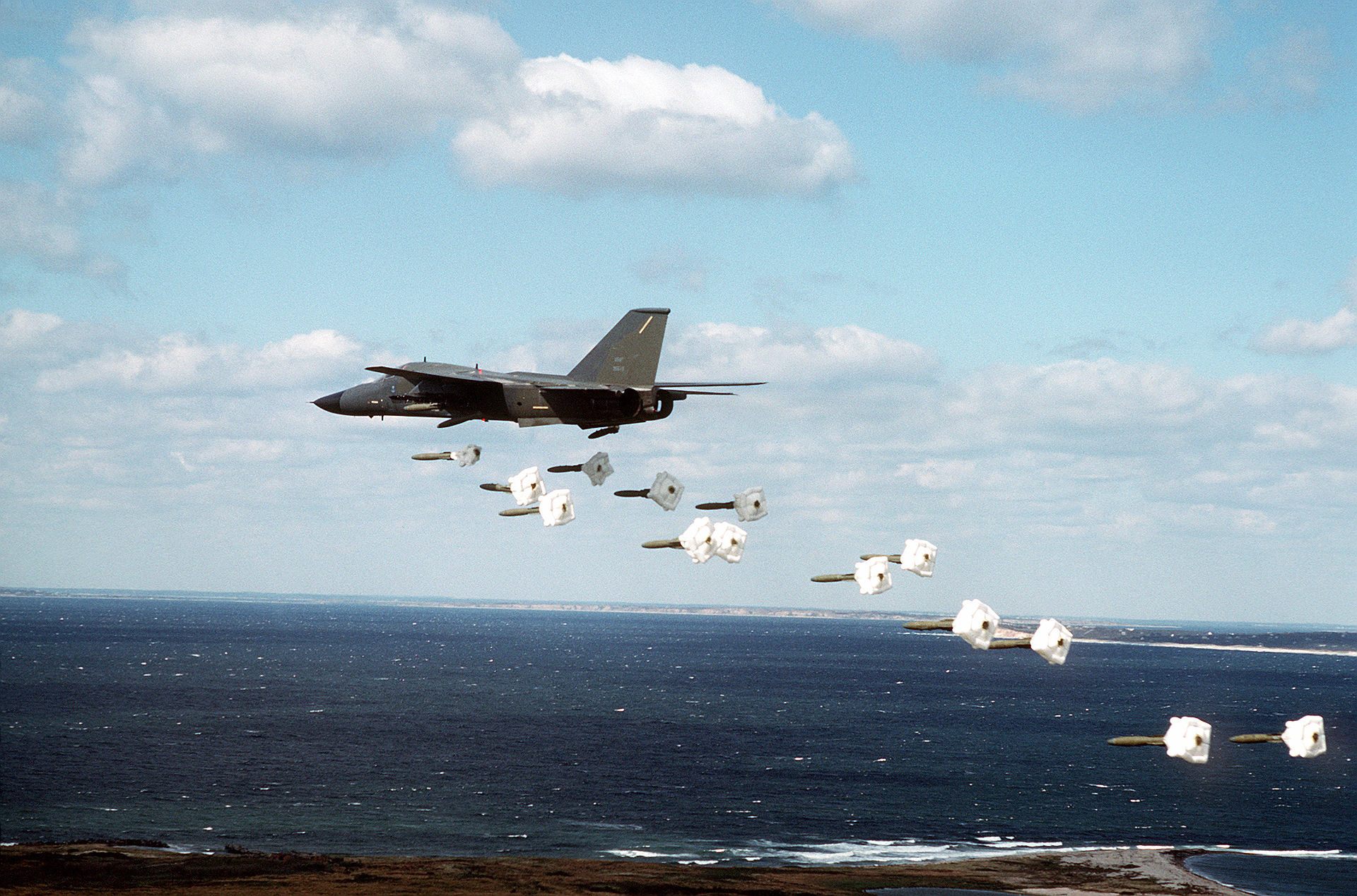 A military plane drops practice bombs over the coast of Nomans Land Island.