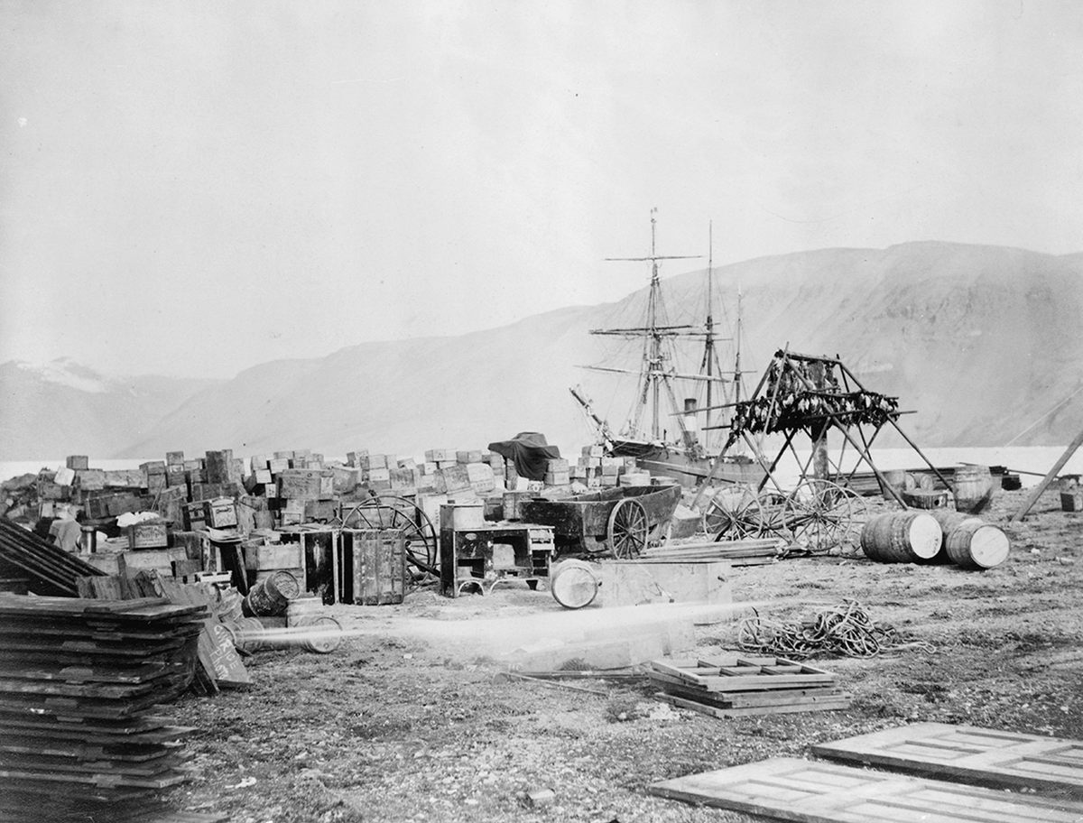 Expeditionary stores, a game stand, and the steamer Proteus in Discovery Harbor during the Bay Expedition of 1881-84.