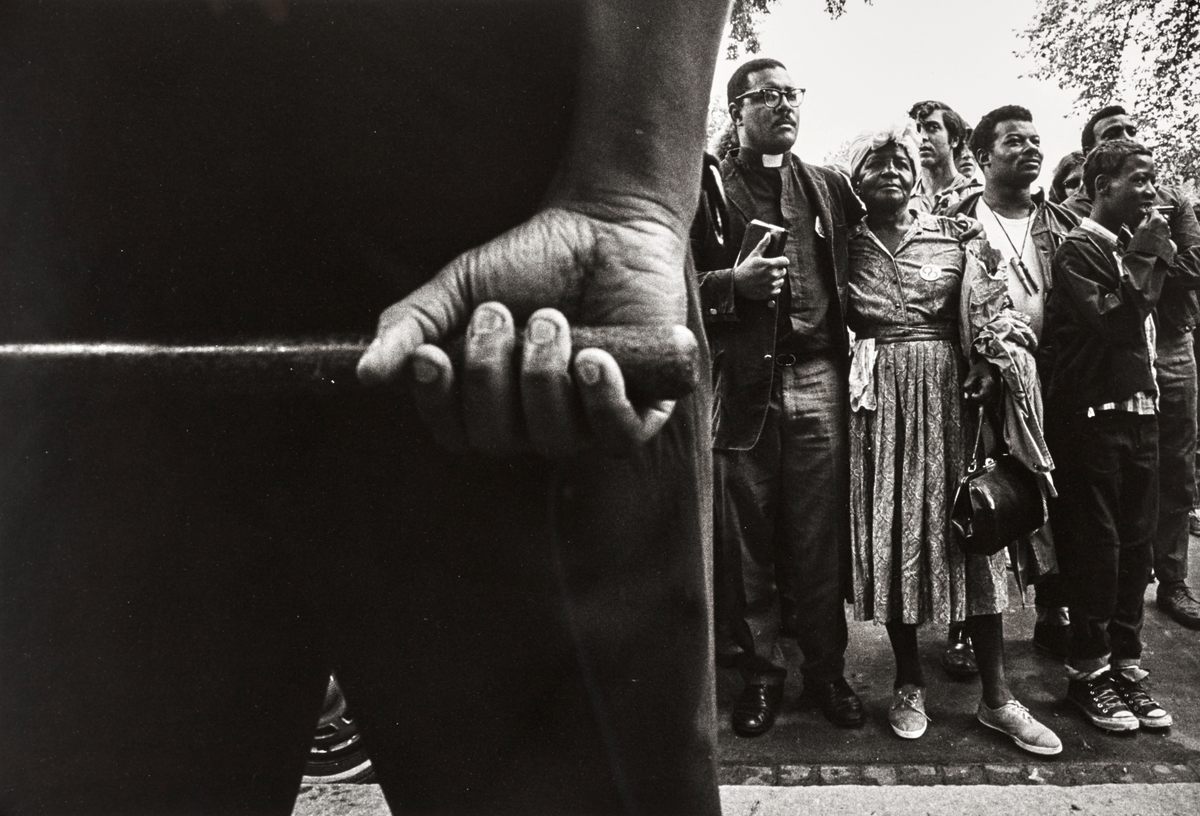 Protesters, seen from behind a police officer.