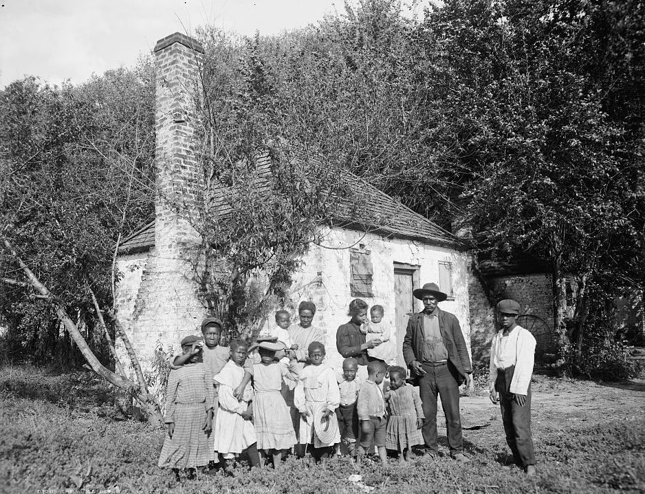 An African-American family standing in front of former slave quarters at the Hermitage Plantation in Savannah, Georgia.