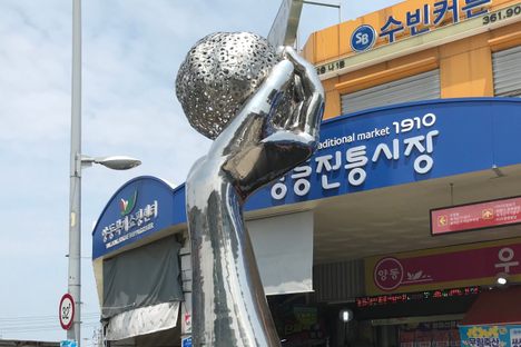 At Yangdong Market in Gwangju, a statue of a hand holding jumeokbap aloft honors the humble food. 