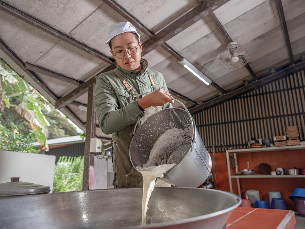 Chang Shun-Hsing pours the soy milk into the wok.