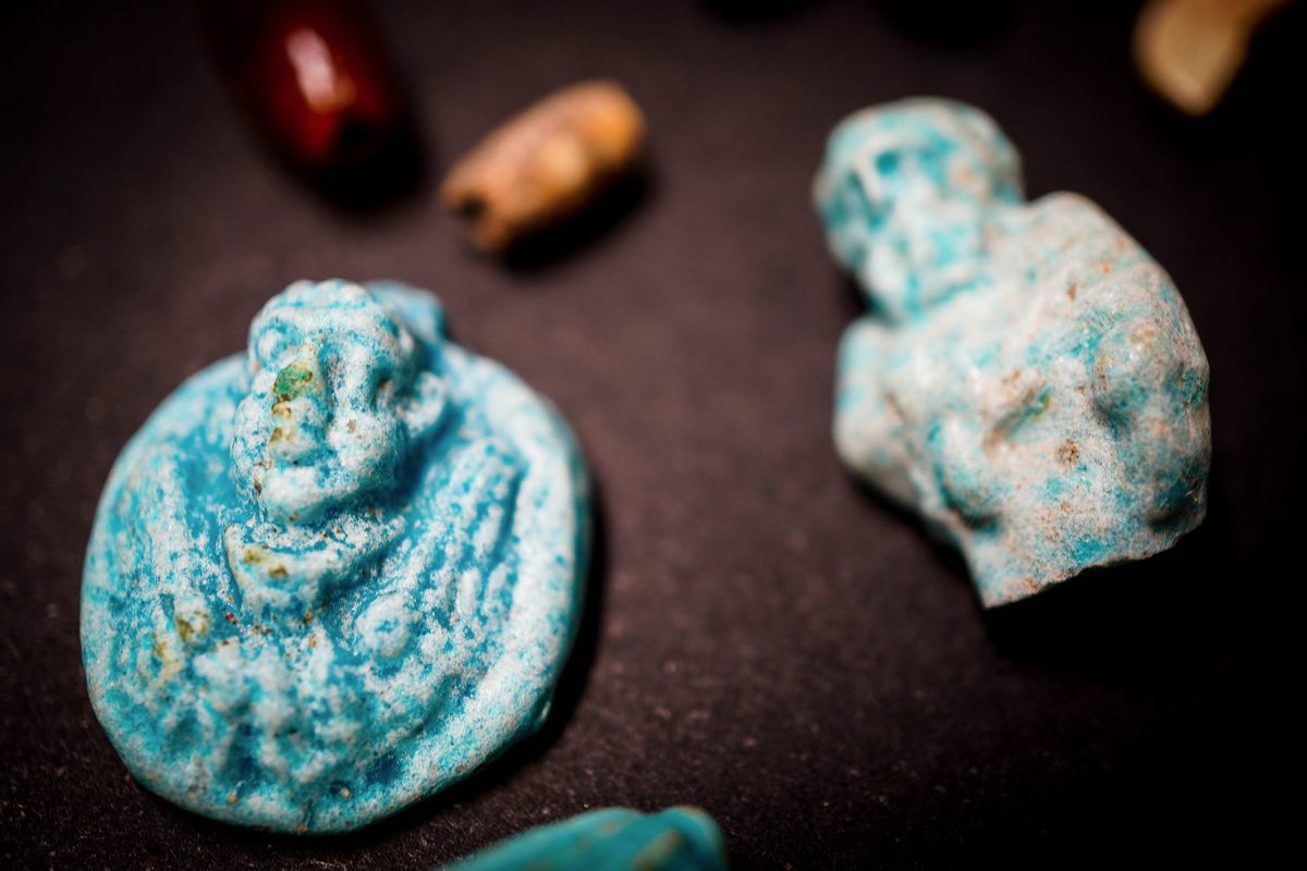 A circular pendant that may represent the Egyptian god Bes, a protector of households as well as mothers, children, and childbirth.