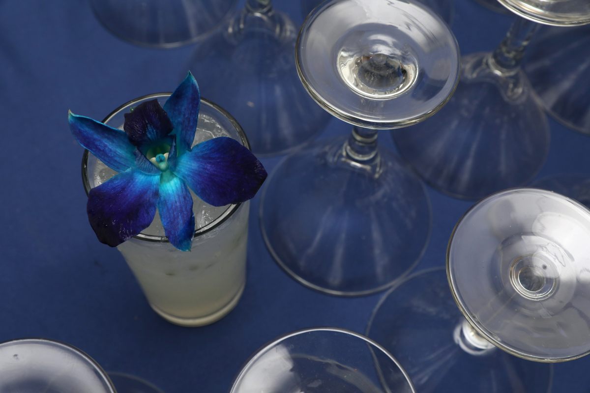 The custom-designed Hidden Gem Gimlet, garnished with a sapphire-colored blossom.