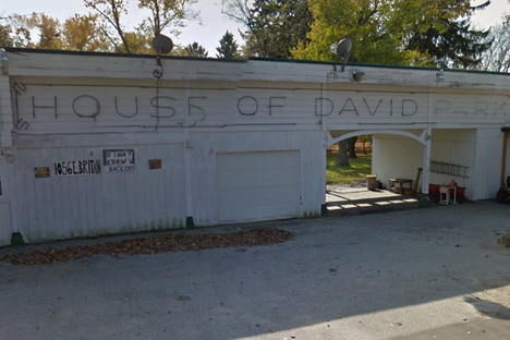 The derelict entrance to House of David Park. A sign below says "If I don't know u back off."