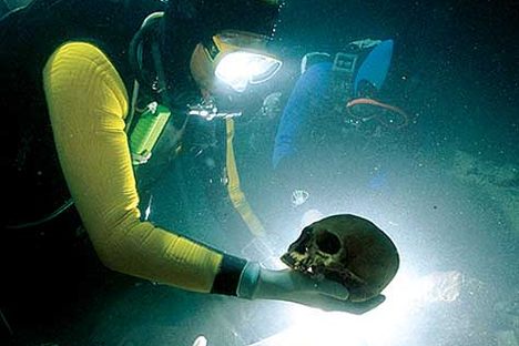 Octavio Del Río recovering the skull of an ancient ancestor from a sacred cenote inside a cave near Tulum, Mexico.