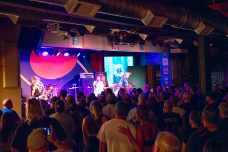 A crowd of patrons enjoys a live show at Songbirds Studio.