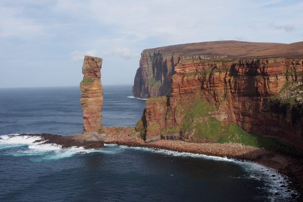 A teeny climber on top of the Old Man of Hoy.