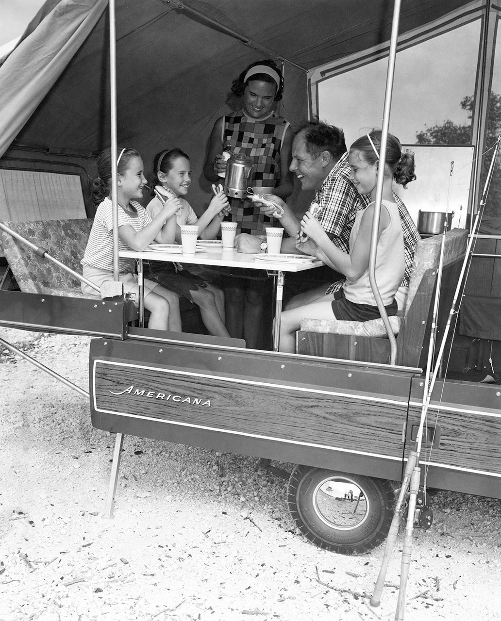 Family vacationers of the 1950s and ’60s furthered camping’s mass-market appeal and created an industry built around holiday travel in luxury recreational vehicles. Here, a family of five share a meal in a pop-up camping trailer, circa 1966.