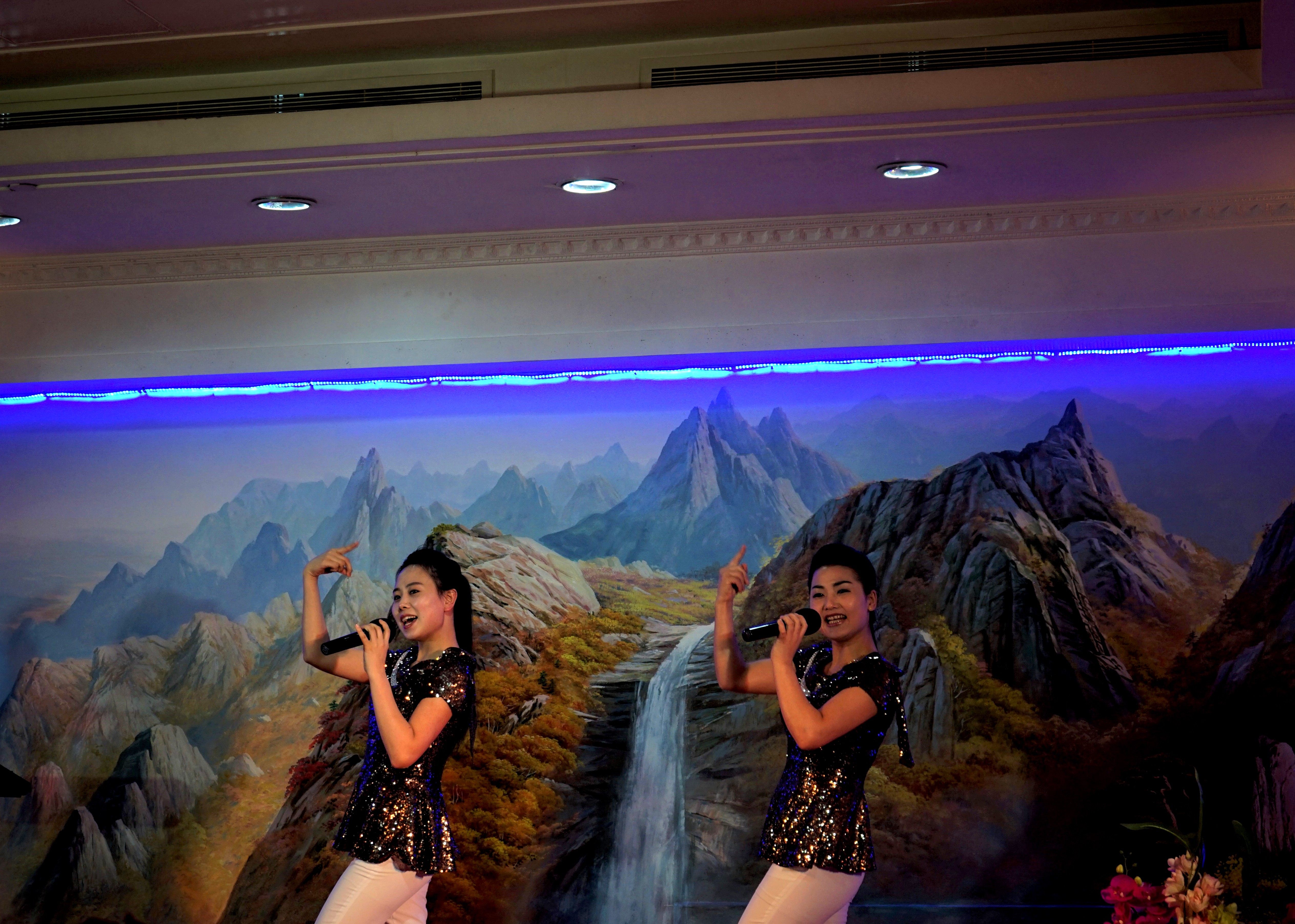 Two performers sing karaoke at Okryu-gwan's Dubai location.