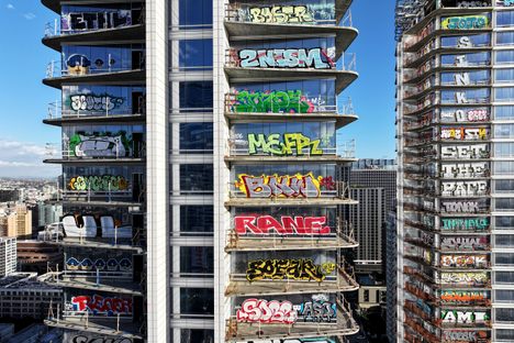LOS ANGELES, CALIFORNIA - FEBRUARY 02: An aerial view of graffiti spray painted by taggers on at least 27 stories of an unfinished skyscraper development located downtown, with Cryto.com Arena visible (LOWER R) on February 2, 2024 in Los Angeles, California. Construction of the $1 billion Oceanwide Plaza luxury real estate development stalled in 2019 after a China-based developer ran out of funding leaving the three-tower project uncompleted. The project is located across the street from the Crypto.com Arena where the Grammy Awards will be held on February 4. (Photo by Mario Tama/Getty Images)