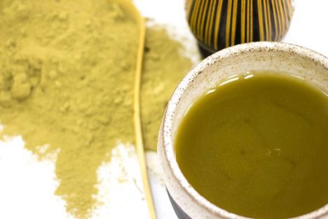 Kratom tea with powder and whisk in the background.