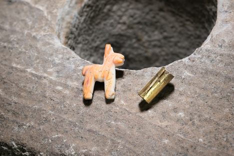 The carved-shell llama and the gold roll are recurring motifs in Inca offerings, submerged and otherwise.