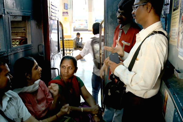 Deaf commuters converse in a Mumbai railway car.