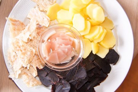 Clockwise from top right: potatoes, whale meat, and dried fish, with blubber in the center.