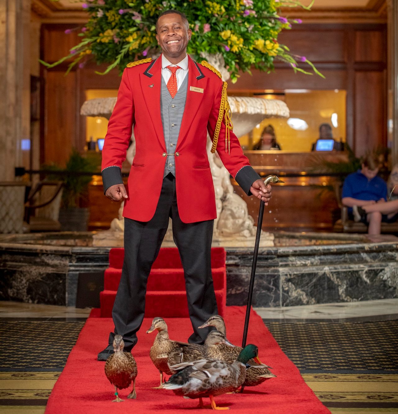 The Peabody hotel's duckmaster, Kenon Walker, poses next to his five waddling charges.