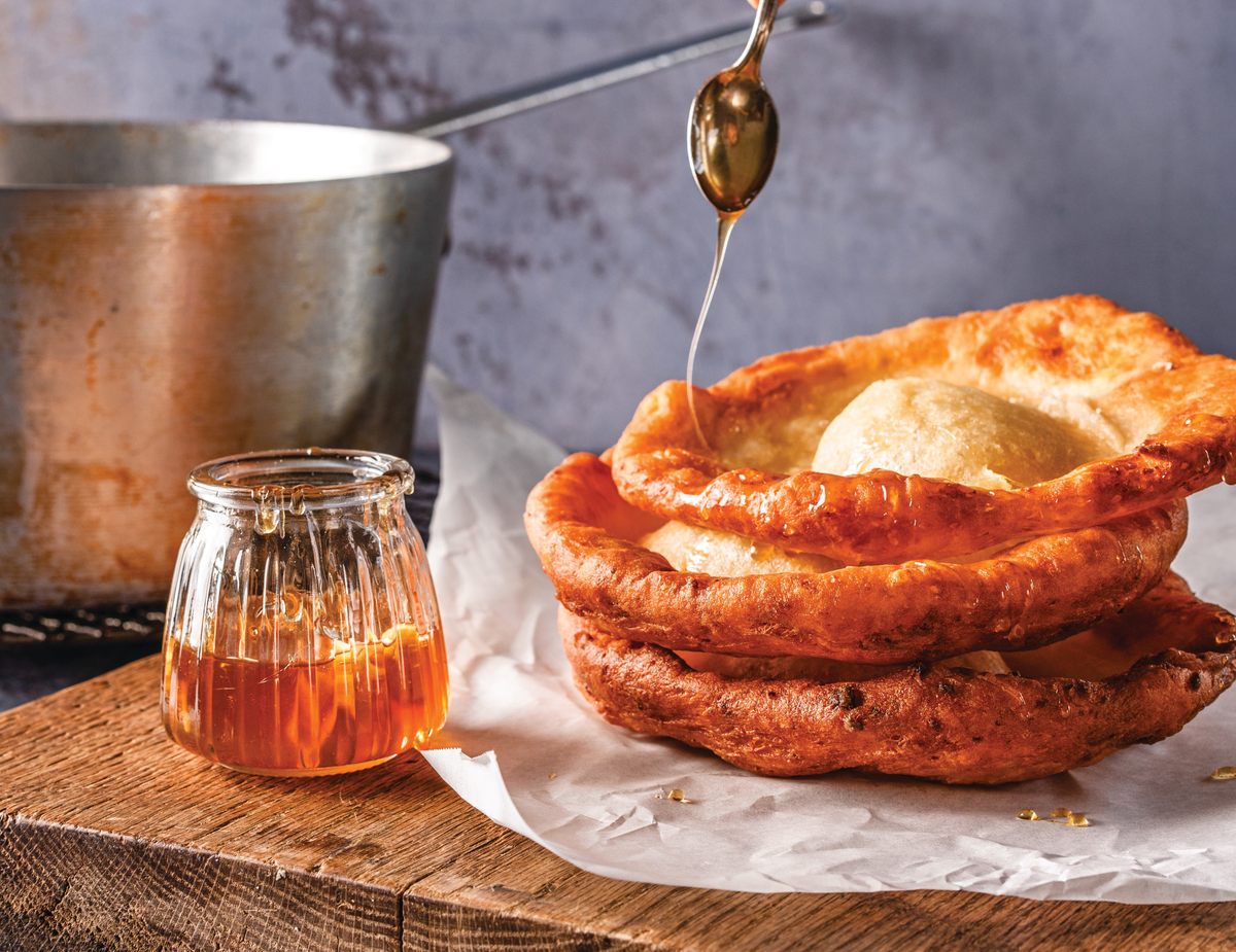 <em>Lángos</em>, a type of fried potato bread, is delicious when drizzled with fermented garlic honey.