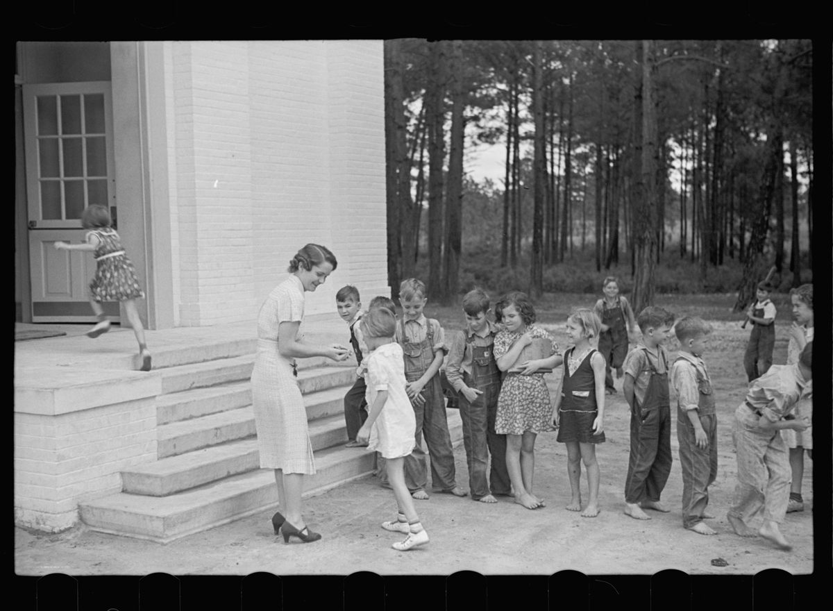 <em>Schoolteacher and children, Irwinville School, Georgia.</em>