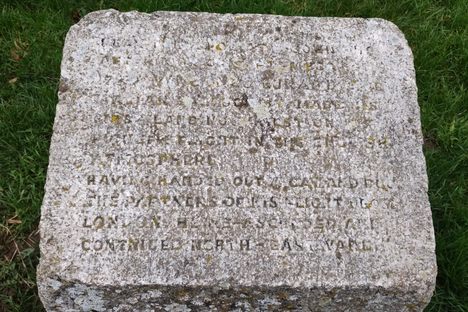 The memorial stone text, which is difficult to read.