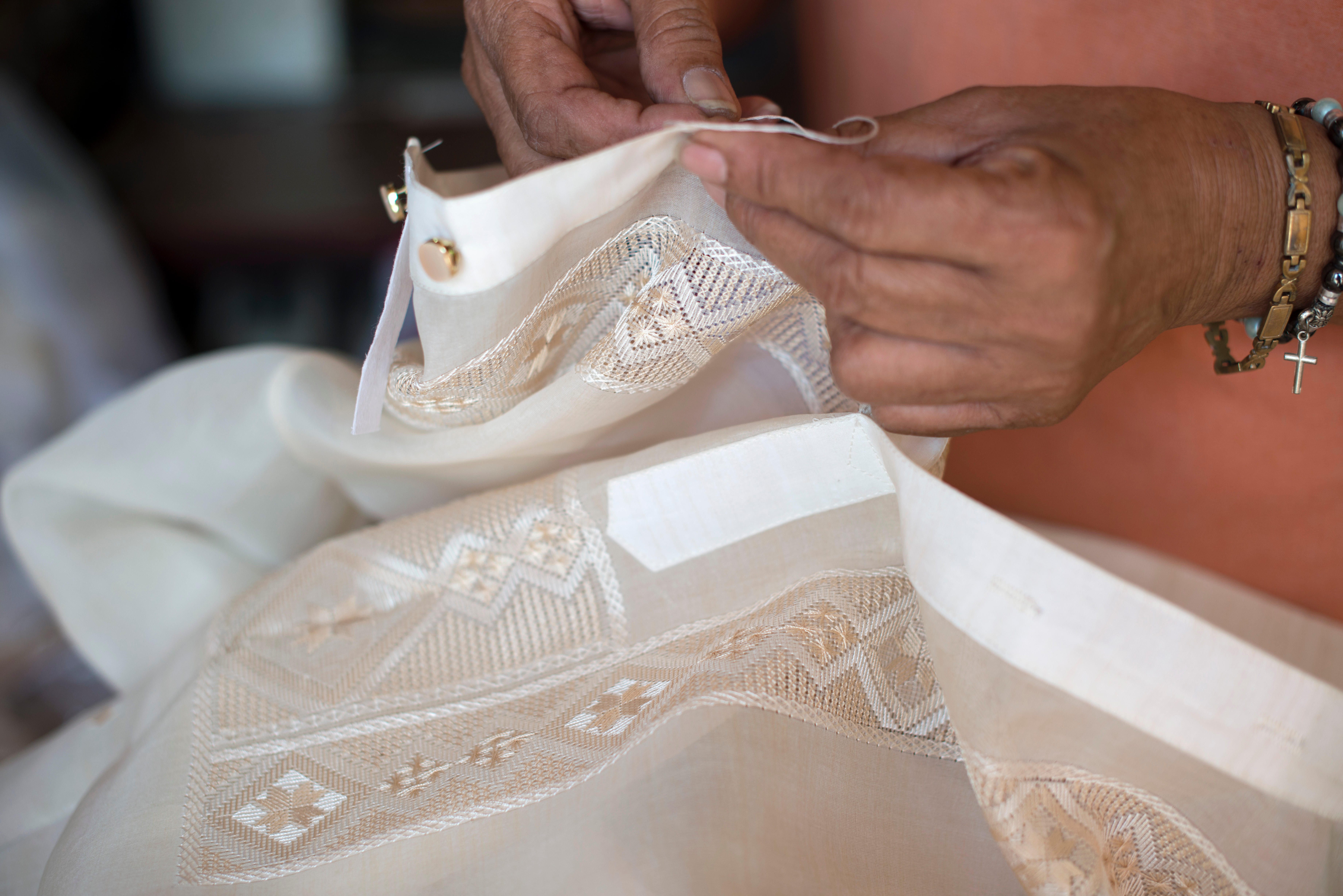 Sewing buttons onto a Barong Tagalog garment in the Philippines.