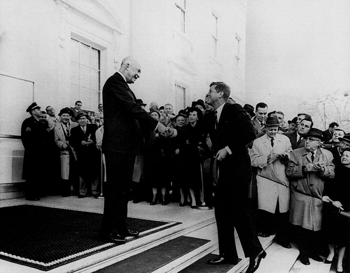 Eisenhower and Kennedy shake hands on the White House Steps.