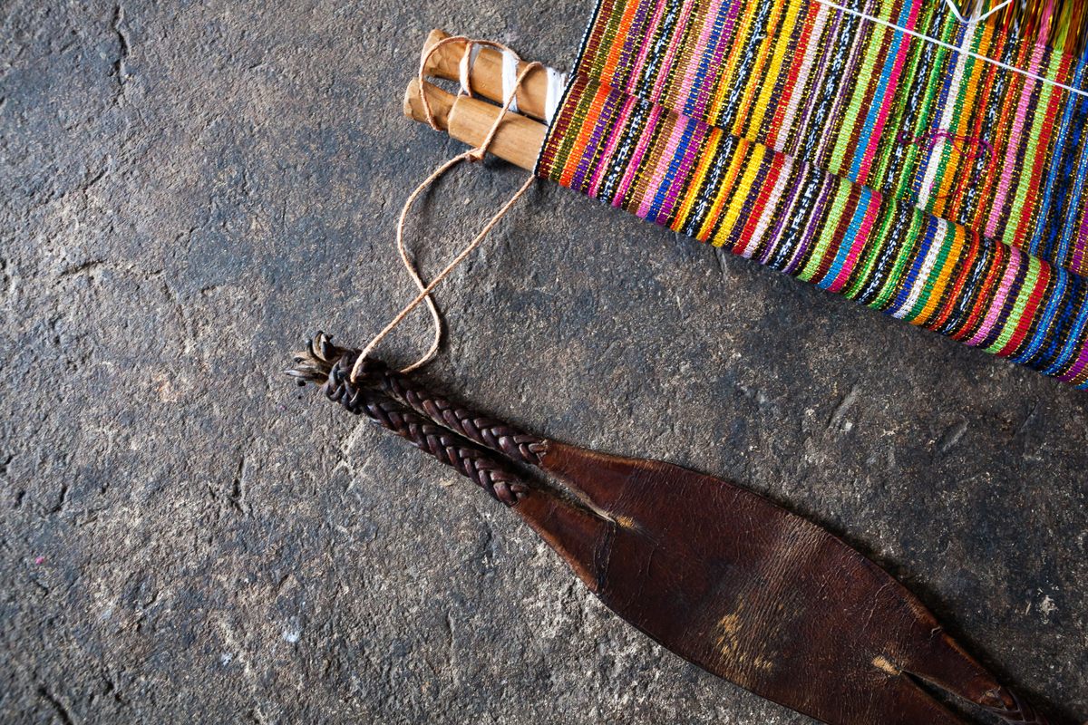 The leather strap arrangement that weavers fasten around their backs when weaving, to keep the threads stretched.