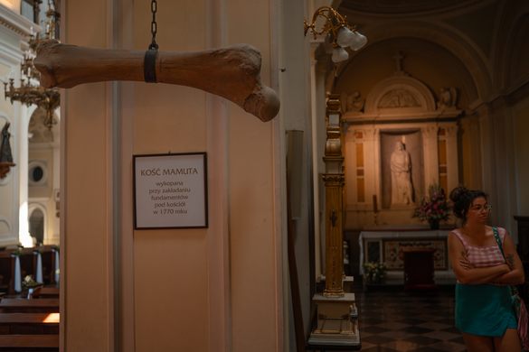 A large bone hangs from a chain in a church.