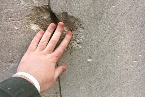 Touch a Wall Street building scarred by a 1920 terrorist bombing.