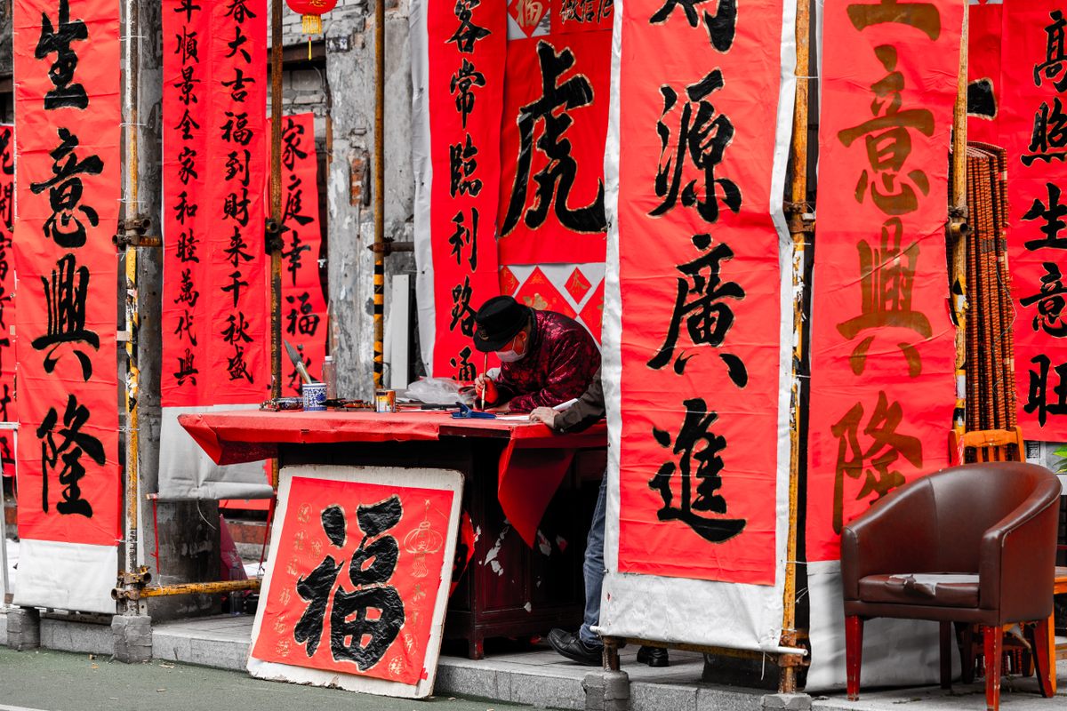 A vendor writes and sells Spring Festival couplets at a stall in Foshan, Guangdong Province, China. (January 9, 2022)