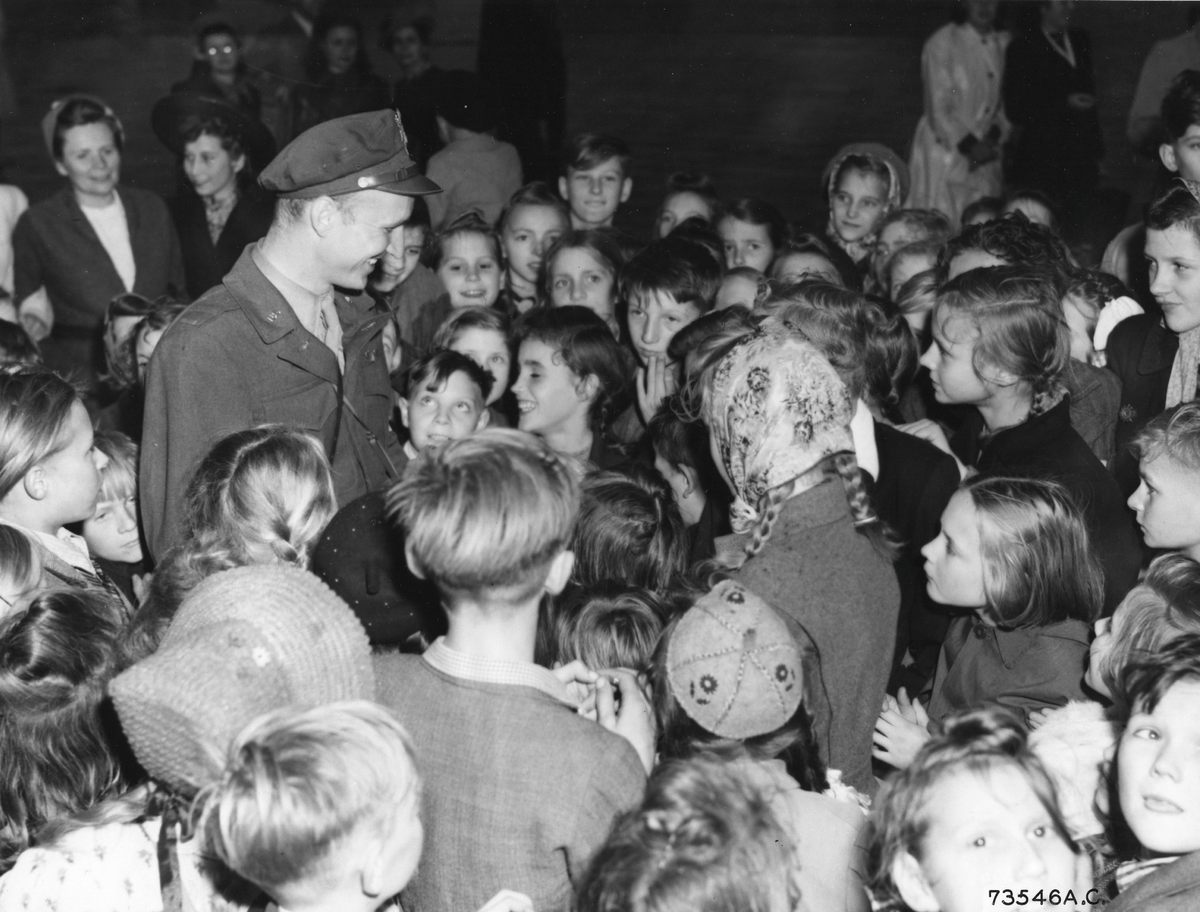 A group of Berlin children meet Lieutenant Gail Halvorsen, who dropped candies over Berlin in tiny parachutes, 1949.