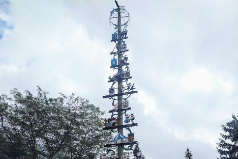 A towering maypole surrounded by trees