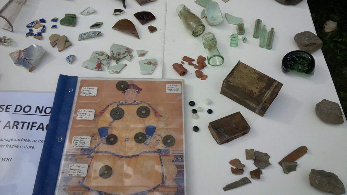 An archaeology display from Barkerville showcases pottery shards, medicine bottles, and Qing Dynasty coins.
