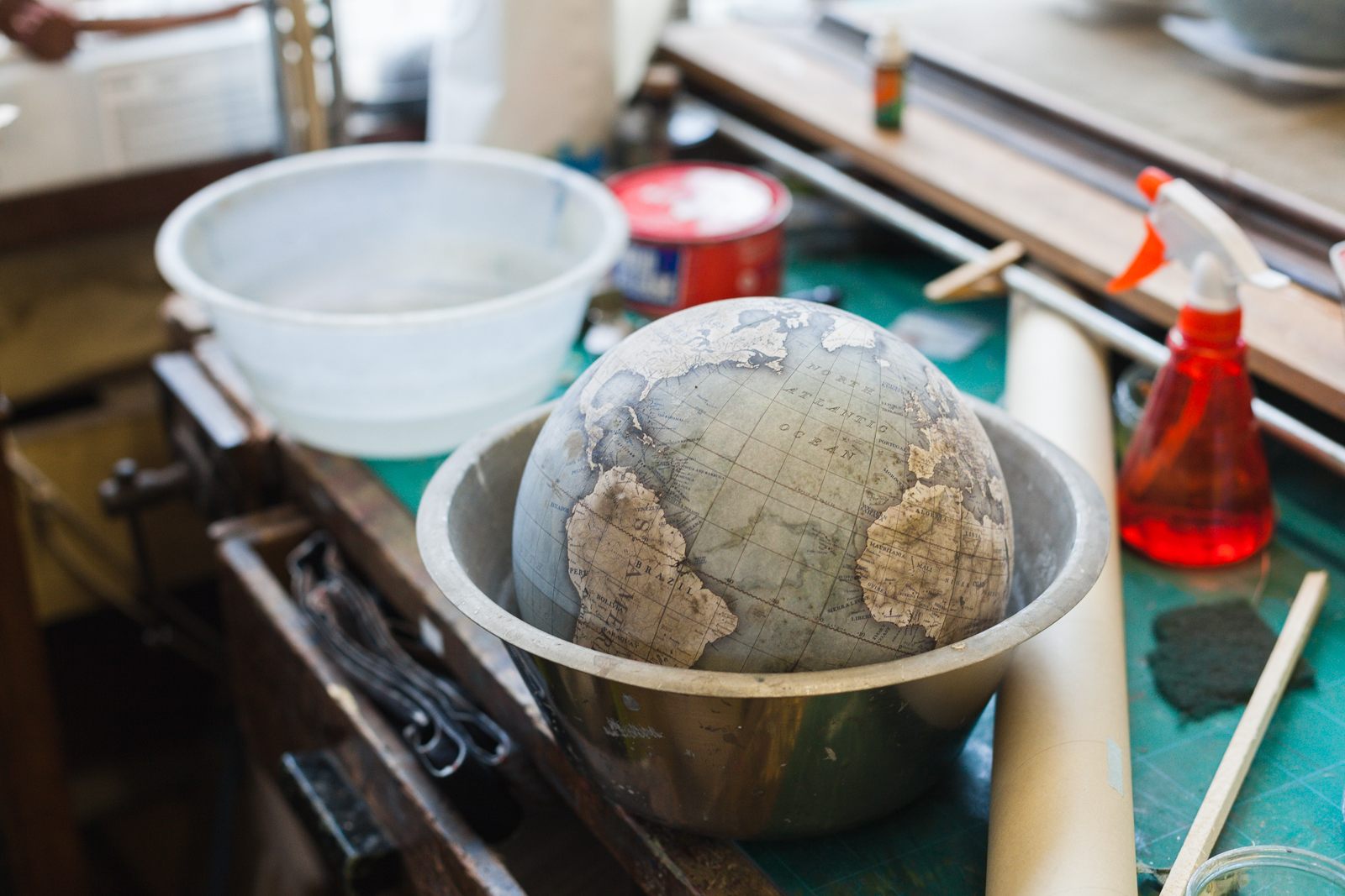 Apprentices train for at least 6 months before making the smallest sized globes, the 23cm mini desk globe. At the end of each day, their practice globes are soaked in water and stripped back so they can practice again the next day. Photo by Ana Santl.