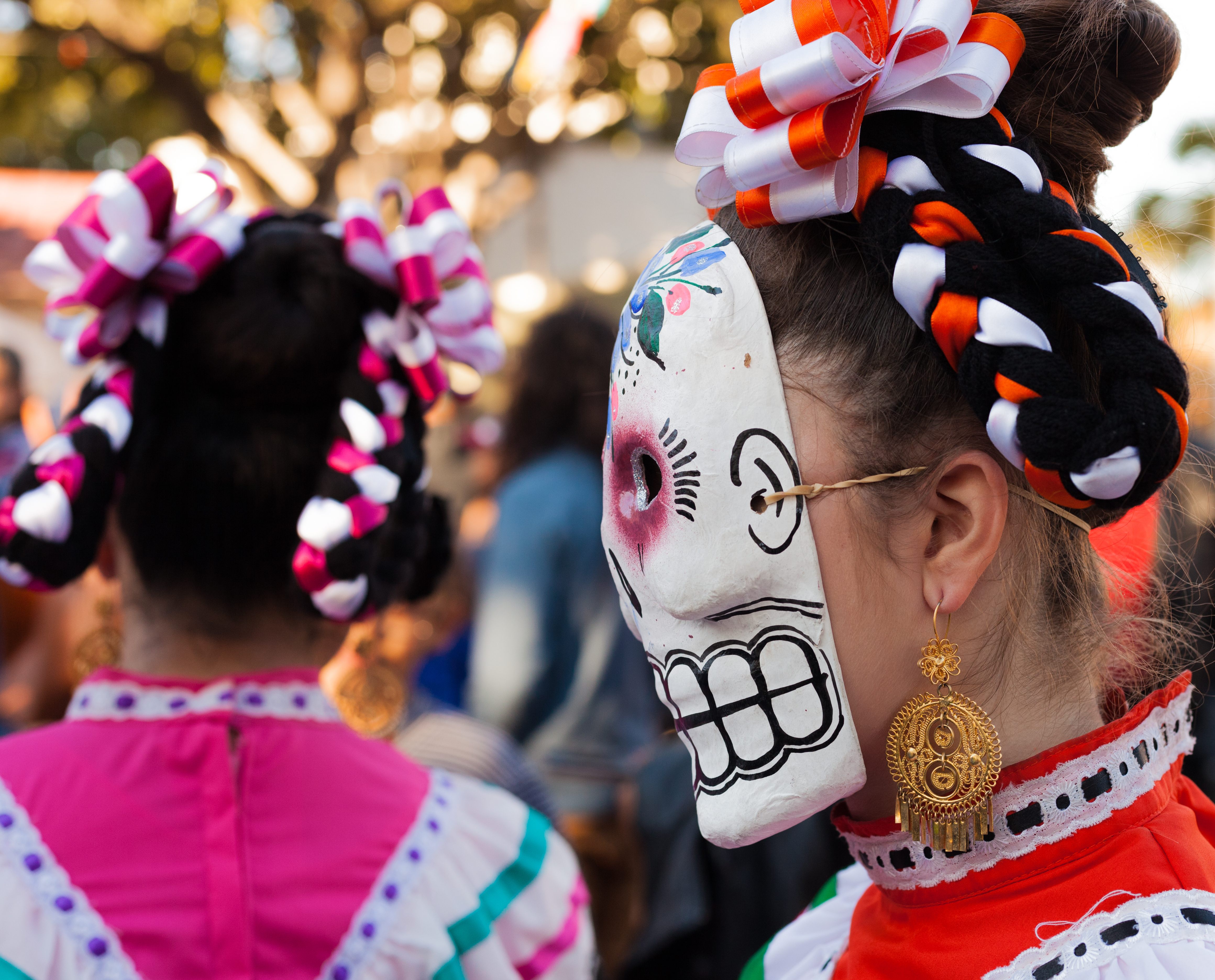 Costumed women celebrate in a Día de los Muertos parade.