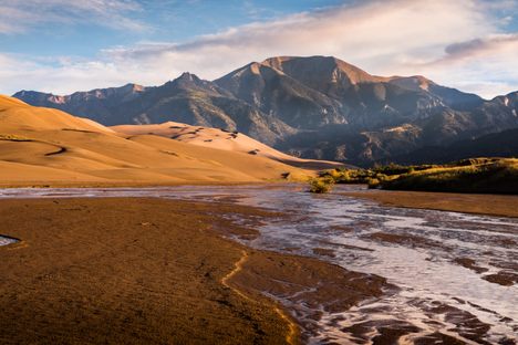 The creek lays at the feet of a series of dramatic sand dunes.