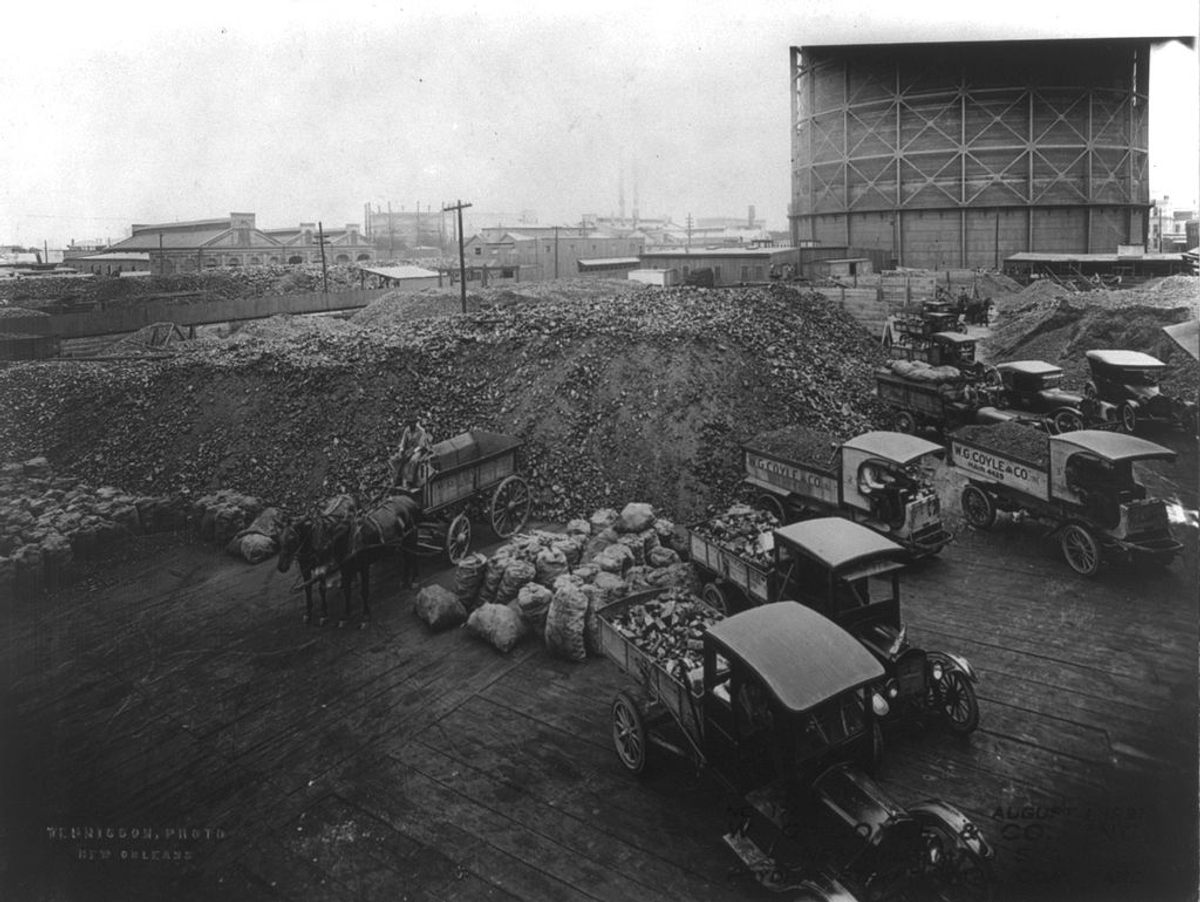 A coal yard in New Orleans, shown in 1921 with the gasworks in the background.
