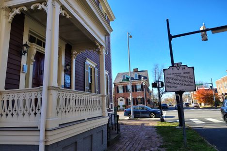 A sidewalk view walking near the home with its historic sign