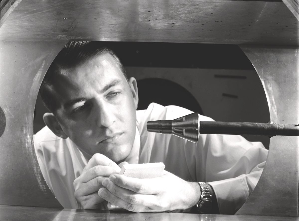 A researcher inspects a mounted Gemini spacecraft model in the 11-inch Hypersonic Tunnel, 1962.