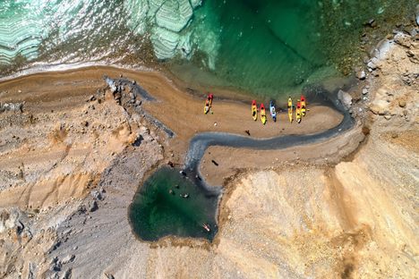 Kayakers visit a slumped sinkhole on the Dead Sea Coast. 