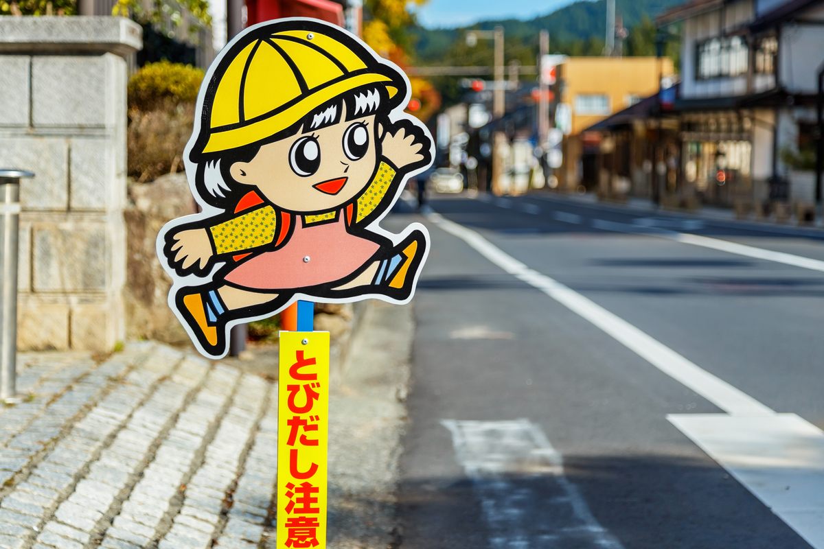 Over the years, Tobita-kun has taken many forms, in some cases even more in a cartoon spirit, and with a raised arm indicating "I'm crossing." 