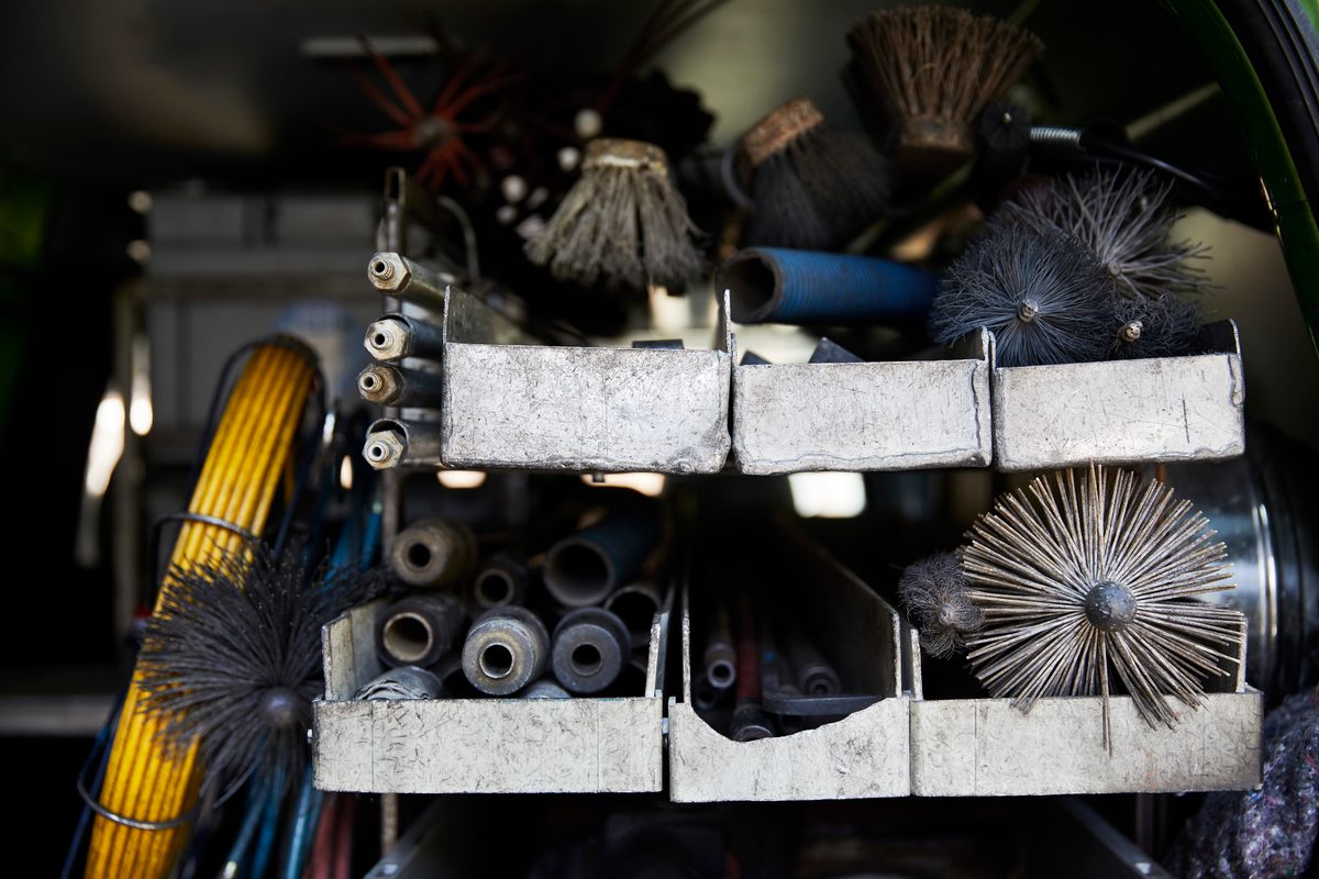 Brooms are no longer the primary tool in the chimney sweep's kit.  Modern heating systems also require dust and water vacuums, steel brushes, and high-pressure cleaners. 
