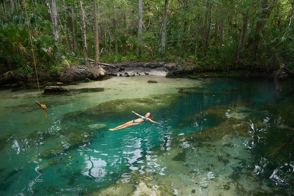 A swimmer floats in the pool formed by the 30-foot crack in the riverbed.