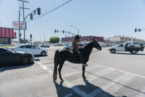Kenneth Atkins and his horse Ebony wait for the light to turn green at the intersection of Wilmington Avenue and Alondra Boulevard, 