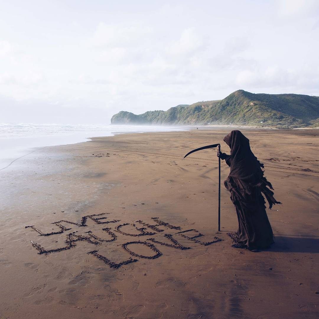 An ironic sand message from the Swim Reaper.