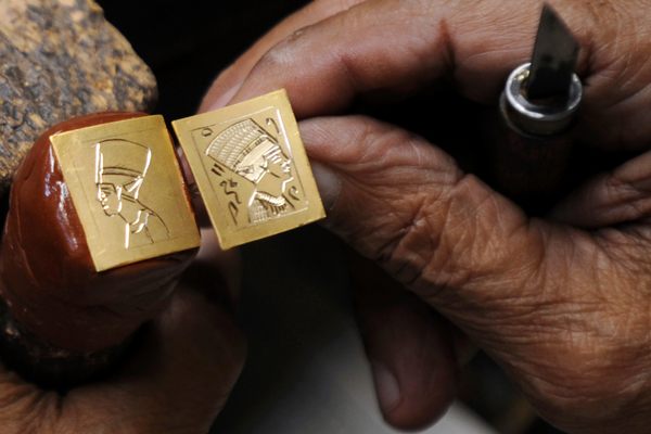 A Cairo goldsmith works on golden rings depicting a pharaoh.
