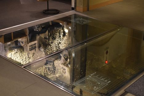 The archaeological remains under the glass paneling.